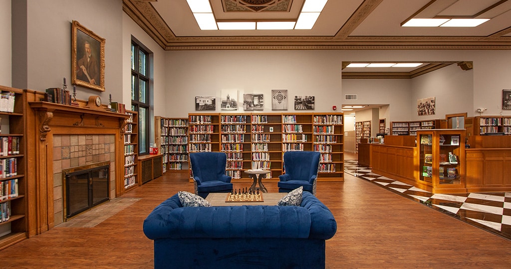library interior with fireplace and blue sofa