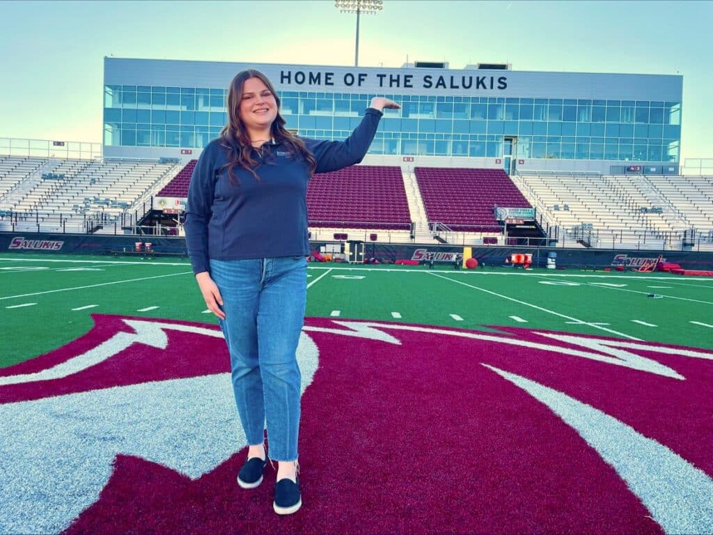 Elizabeth Vatole poses for a photo on a football field.